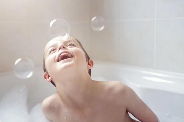 boy blowing bubbles in the bath tub