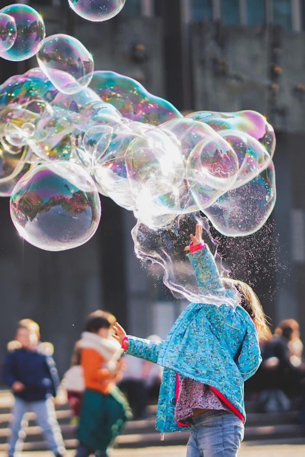 child breaking a huge bubble