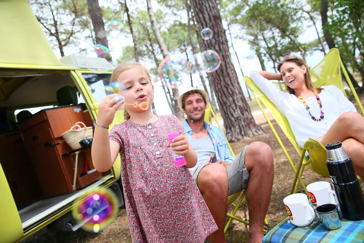 girl blowing bubbles camping
