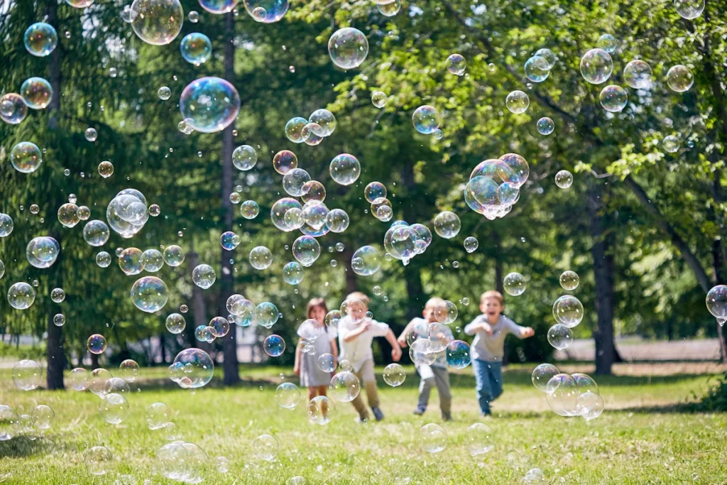 kids chasing bubbles at a park