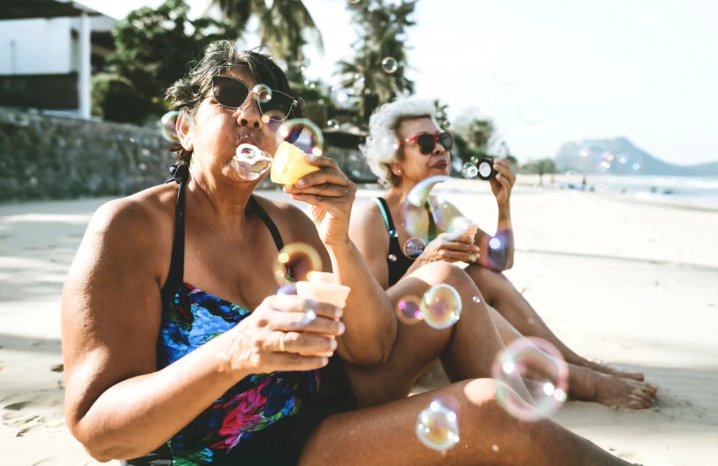 mature women blowing bubbles at the beach