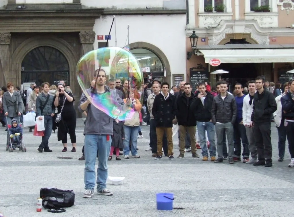 men watching someone make huge bubbles