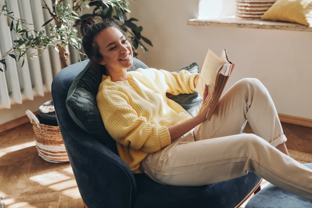 young woman enjoying permission to pause and read a book